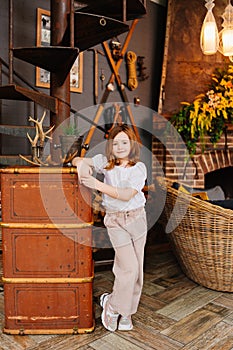 Cute little girl with dark hair in retro country house interior.