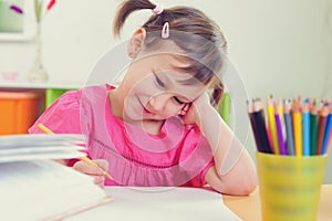 Cute little girl drawing with colorful pencils