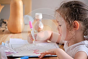Cute little girl drawing with invisible ink on papaer