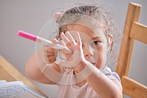 Cute little girl drawing with invisible ink on papaer