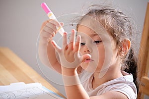 Cute little girl drawing with invisible ink on papaer