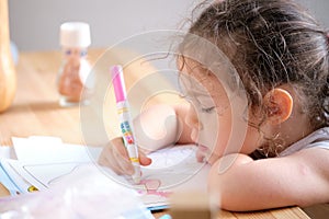 Cute little girl drawing with invisible ink on papaer