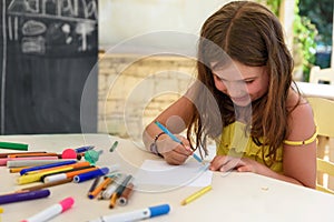 Cute little girl drawing and painting at kindergarten. Creative activities kids club
