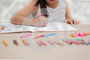 Cute little girl drawing picture on home interior background.