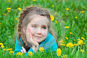 Cute little girl dreaming on green grass
