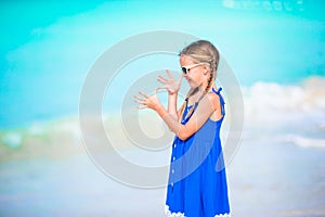 Cute little girl in dress at beach having fun. Funny girl enjoy summer vacation.