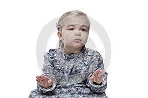 Cute little girl in a dress with a soothing face and a soothing gesture with her hands. Funny child, picture for memes. Isolated