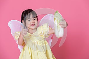 Cute little girl dress up as a angel with white wings holding cabbage and thumb up.Healthy eating and lifestyle concept. Green