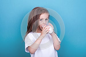 Cute little girl drinking milk from glass