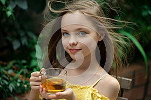 Cute little girl is drinking tea