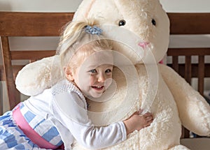 Cute little girl in Easter dress hugging stuffed bunny