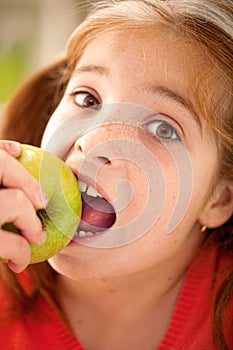 Cute little girl eating an apple