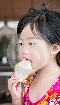 Cute little girl eating bread