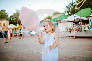 Cute little girl eating candy floss on a stick