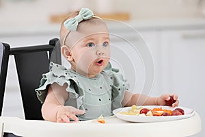 Cute little girl eating healthy food at home