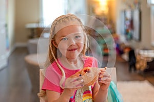 Cute little girl eating a jelly donut