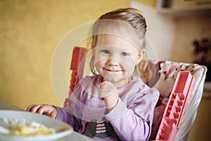 Cute little girl eating porridge photo