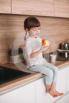 Cute little girl eating red apple