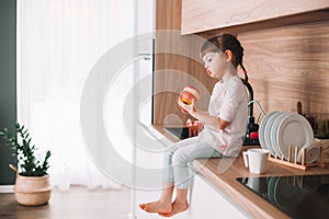 Cute little girl eating red apple