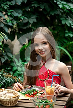 Cute little girl is eating  salad