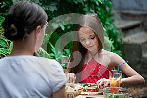 Cute little girl is eating  salad