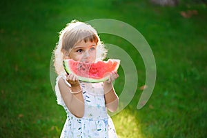 Cute little girl eating watermelon and enjoying picnic