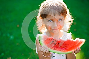 Cute little girl eating watermelon and enjoying picnic