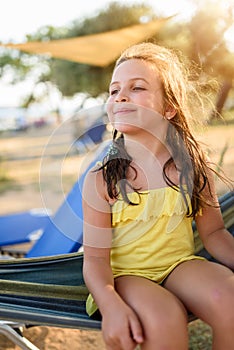 Cute little girl enjoying lying in hammock on the beach