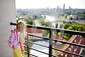 Cute little girl enjoying a view of Vilnius city from the Gediminas hill. Exploring tourist attractions with kids