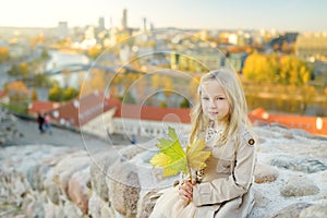 Cute little girl enjoying a view of Vilnius city from the Gediminas hill on sunny autumn day