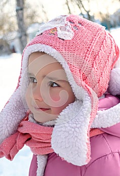 Cute little girl enjoying winter and snow dressed in warm pink c