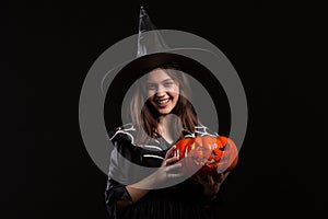 Cute little girl with a evil laugh doing sorcery with a pumpking for halloween