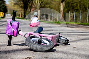 Cute little girl fallen off her bicycle outdoors