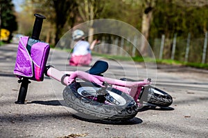 Cute little girl fallen off her bicycle outdoors