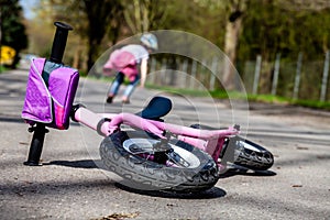 Cute little girl fallen off her bicycle outdoors