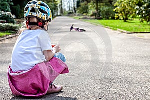 Cute little girl fallen off her bicycle outdoors