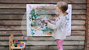 Cute little girl finger painting with various colors