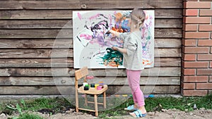 Cute little girl finger painting with various colors