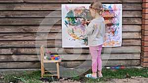 Cute little girl finger painting with various colors