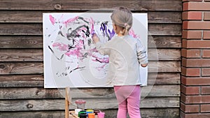 Cute little girl finger painting with various colors