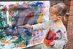 Cute little girl finger painting with various colors