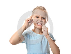 Cute little girl flossing teeth on white background