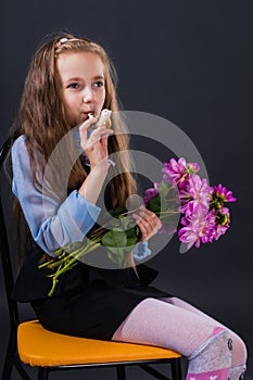 Cute little girl with flowers in her hands retrieves bird trill with bird whistle photo