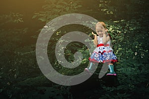 Cute little girl in the forest alone. Fairy tale beautiful light