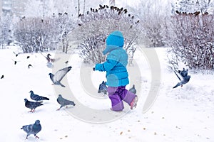 Cute little girl frightening pigeons