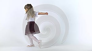 Cute little girl frolicing with joy on white background then folding palms in front of her. Close up. Slow motion