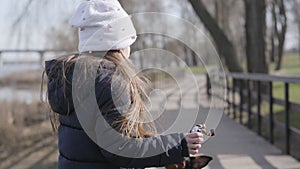 Cute little girl giving food to dog. Nice Caucasian child resting with adorable pet in park. Funny black miniature