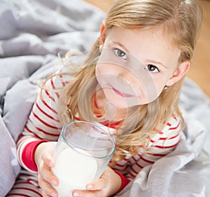 Cute little girl with glass of milk