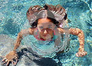 Little girl green eyes children playing at pool at tropical resort in Los Cabos Mexico