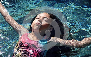 Little girl green eyes children playing at pool at tropical resort in Los Cabos Mexico